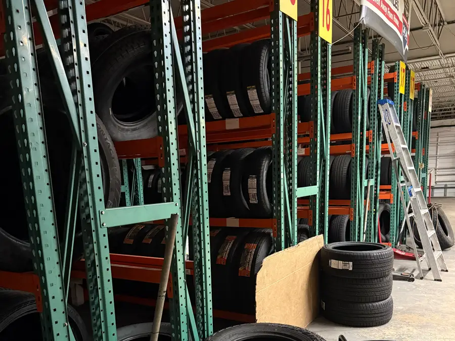 Racks of new tires sorted by rim size at The Tire Place USA in Deerfield Beach