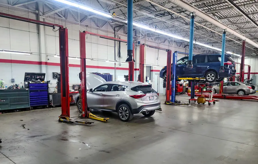 Cars raised on lifts in a clean auto repair shop