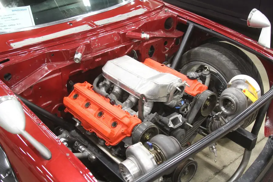 The engine bay of a red classic car