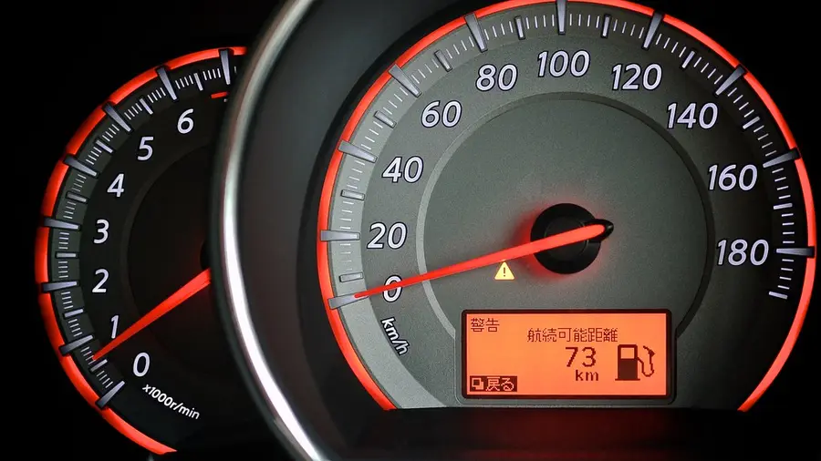 A car speedometer with a warning light lit
